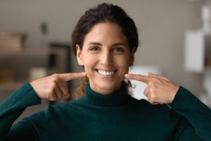 woman pointing to her perfect smile